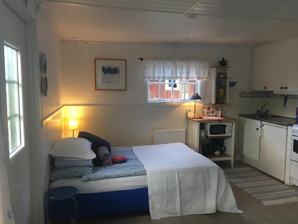 克里斯蒂娜港Lillstugan Elofstorp的一间带床的小卧室和一间厨房