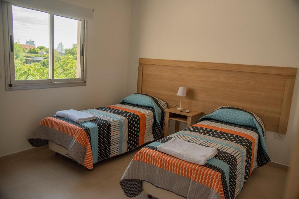 坎帕纳莫拉达套房酒店的带窗户的客房内的两张床