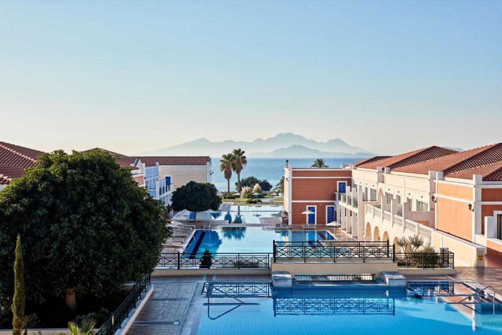 卡尔扎迈纳Porto Bello Royal的享有游泳池的景色,位于一个以山脉为背景的度假胜地