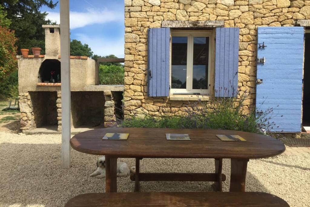 佩尔蒂Cabanon de charme en plein coeur des vignes的一座带熊的建筑前的木桌