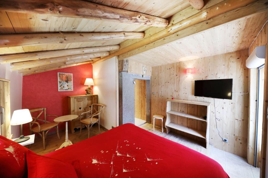 热拉梅Les chalots de Gérardmer, Chambre d'Hôtes的一间带红色床的卧室和一间客厅