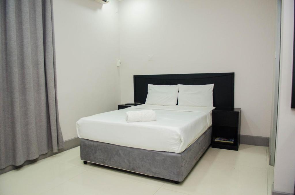 马普托Residencial Horizonte 2的一间卧室配有一张带白色床单的大床
