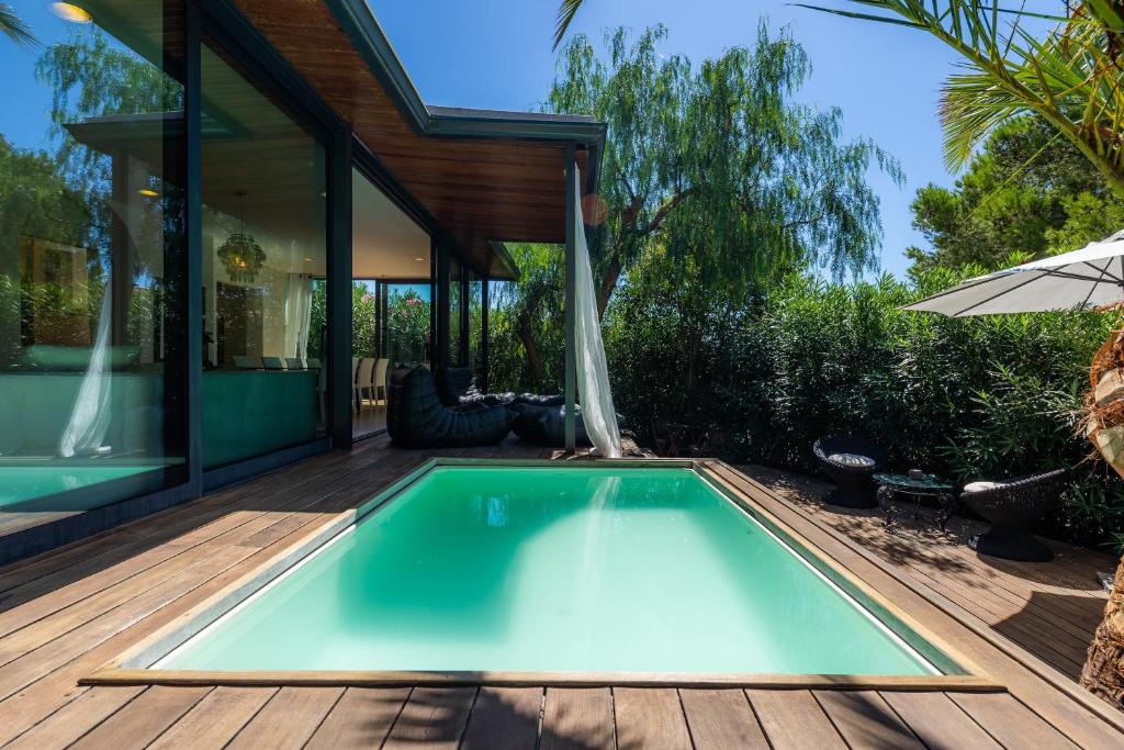 Cala MendiaVilla Lares的一个带房子的木甲板上的游泳池
