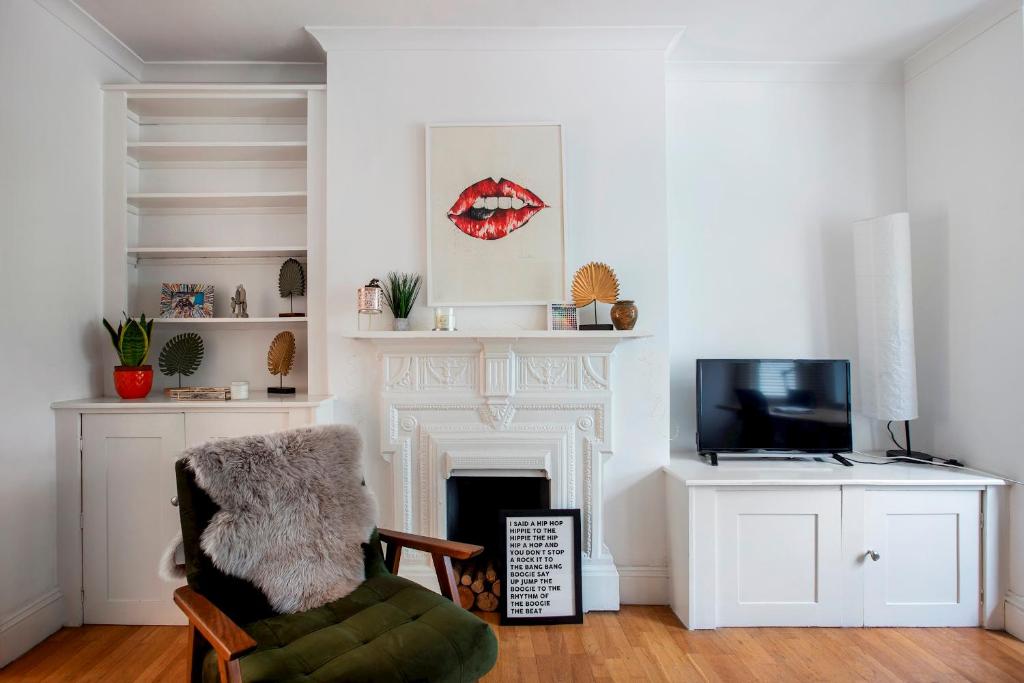 伦敦Pass the Keys - Beautiful stylish flat in South West London的客厅设有壁炉和椅子