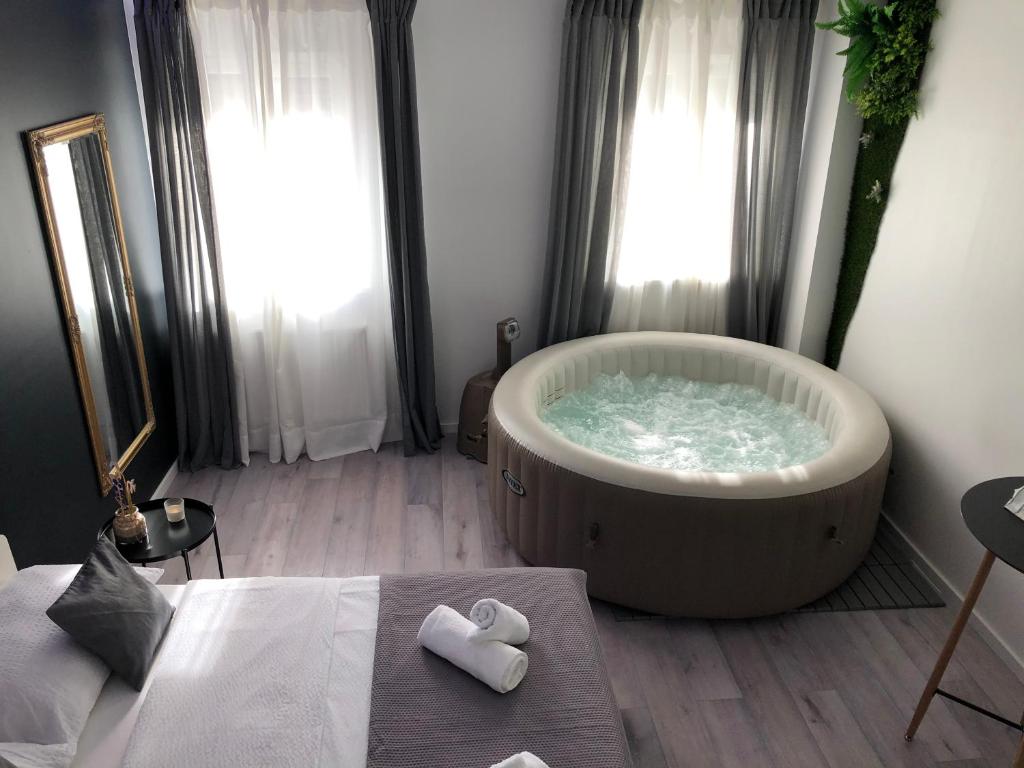 萨格勒布Apartment Zagreb Jacuzzi的楼下设有带大浴缸和2条毛巾的浴室