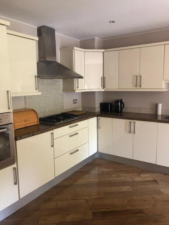 肯梅尔Cromwells Court的厨房配有白色橱柜和炉灶烤箱。
