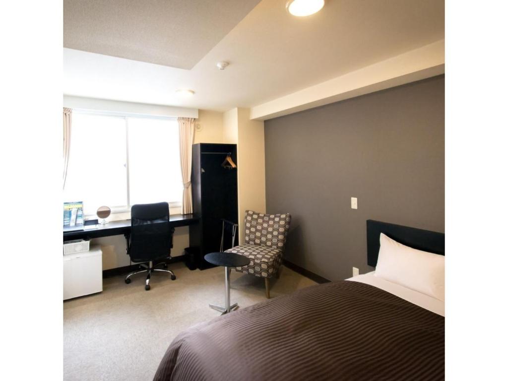 札幌Frame Hotel Sapporo - Vacation STAY 92396的一间卧室配有一张床、一张桌子和一把椅子