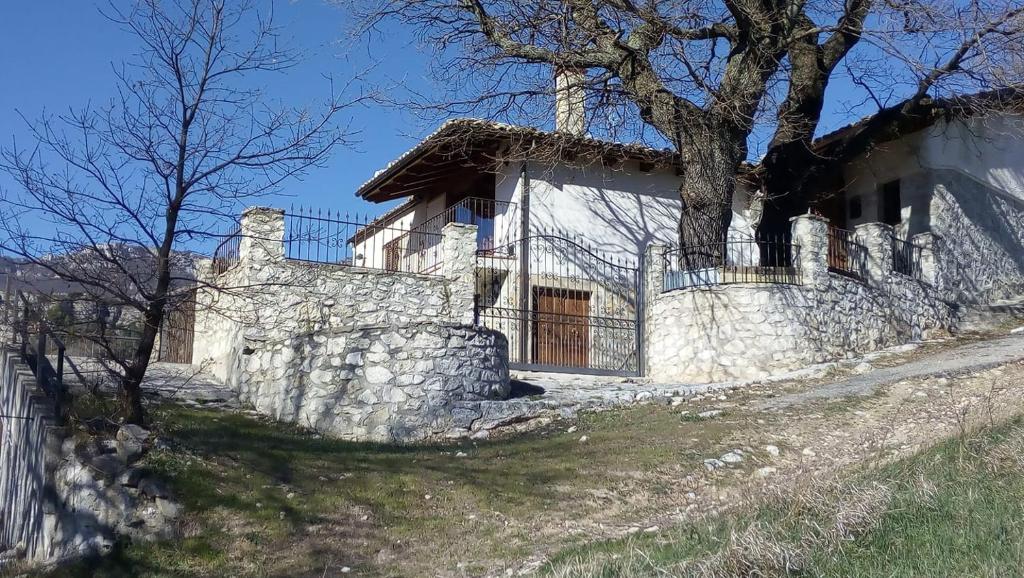 PescosansonescoCase Mastro Renzo tour naturalistico enogastronomico的石头房子,有栅栏和树
