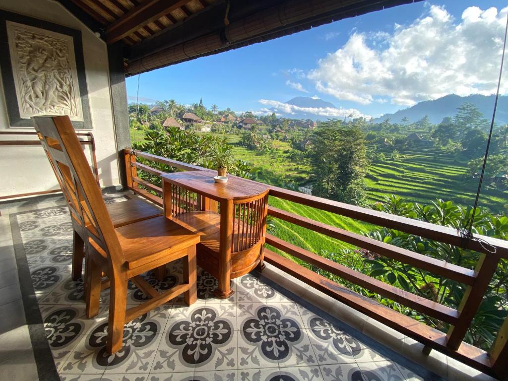 希德门阿扁阿玉别墅酒店的设有一个配有木桌和椅子的阳台,享有美景。