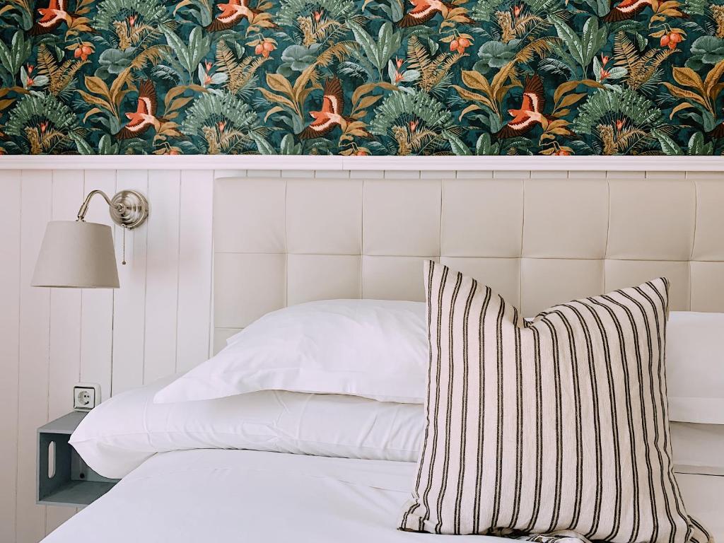 塞维利亚Boutike Guesthouse的一间卧室配有一张带花卉壁纸的床