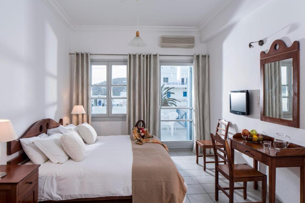 伊奥斯乔拉艾克缇昂酒店的一间卧室配有一张床、一张书桌和一个窗户。