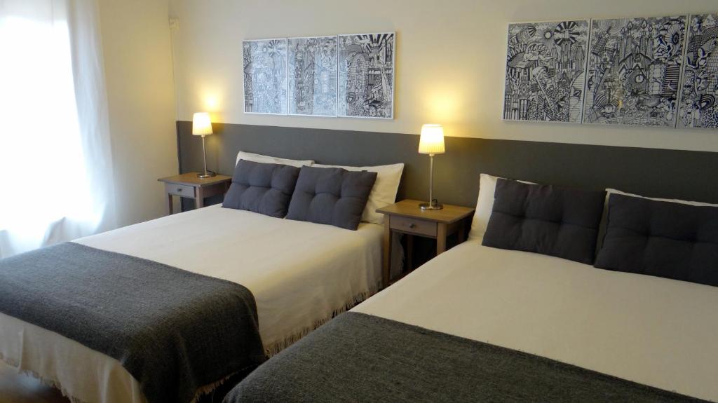 巴塞罗那埃拉尼诺旅馆的酒店客房设有两张床和两盏灯。