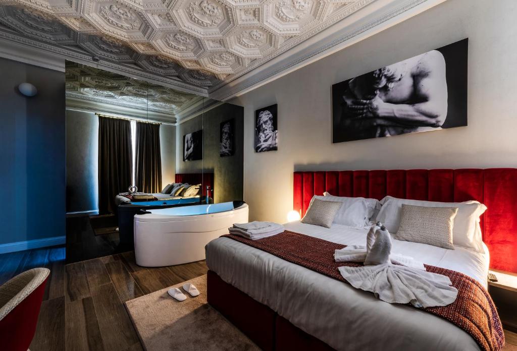 罗马Growel Exclusive Suites San Pietro的一间卧室配有一张大床和红色床头板