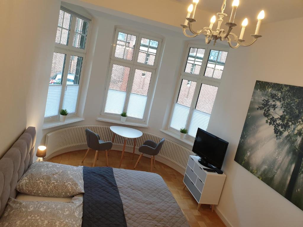 波鸿Apartment Villa Kronenberg的一间卧室设有一张床、一台电视和窗户。