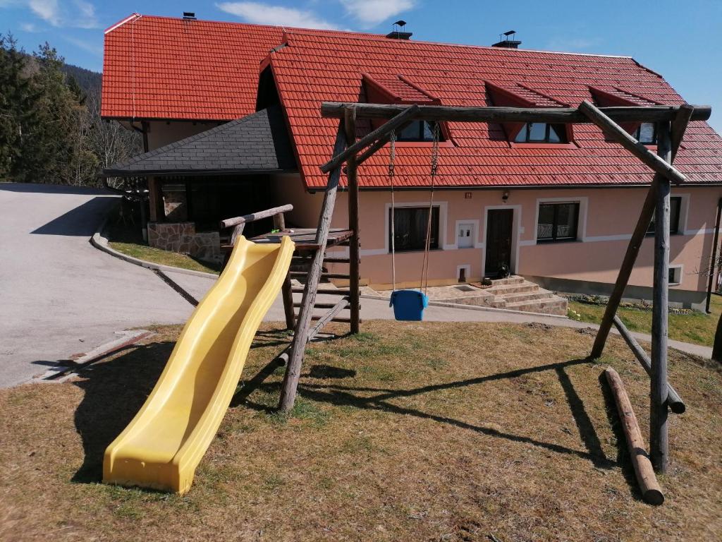 兹雷切Apartment House Koprivnik的房屋前方设有黄色滑梯的游乐场