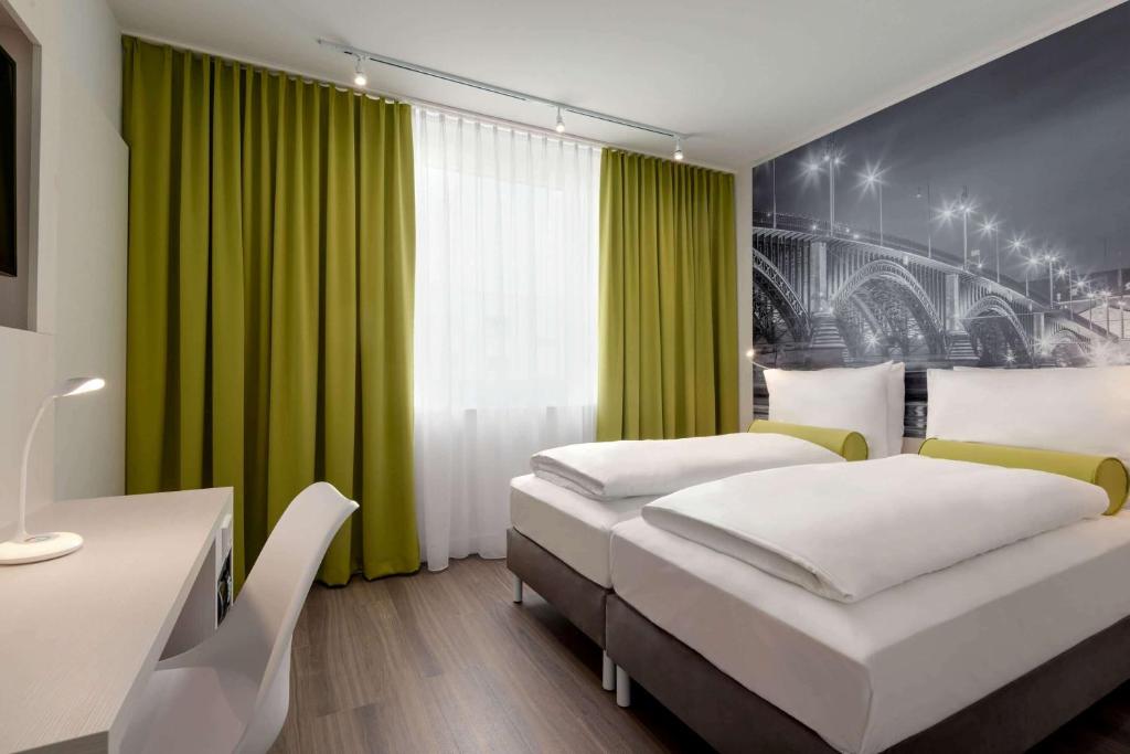 美因茨Super 8 by Wyndham Mainz Zollhafen的一间卧室设有两张床和绿帘