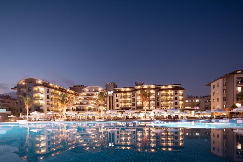 阿拉尼亚Green Garden Resort & Spa Hotel的夜间设有游泳池的酒店