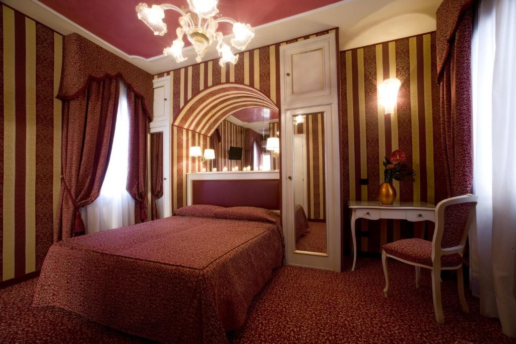 威尼斯阿尔雄酒店的一间卧室配有两张床和镜子