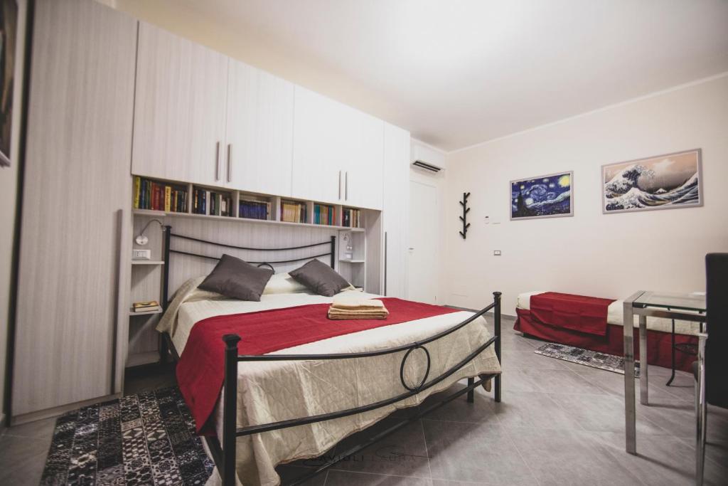 曼托瓦ART & BOOKS bed and breakfast的一间卧室配有一张带红色毯子的床