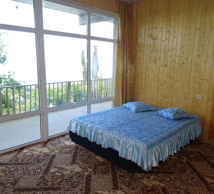 加格拉Гостевой дом с видом на море的一间卧室设有一张床和一个大窗户