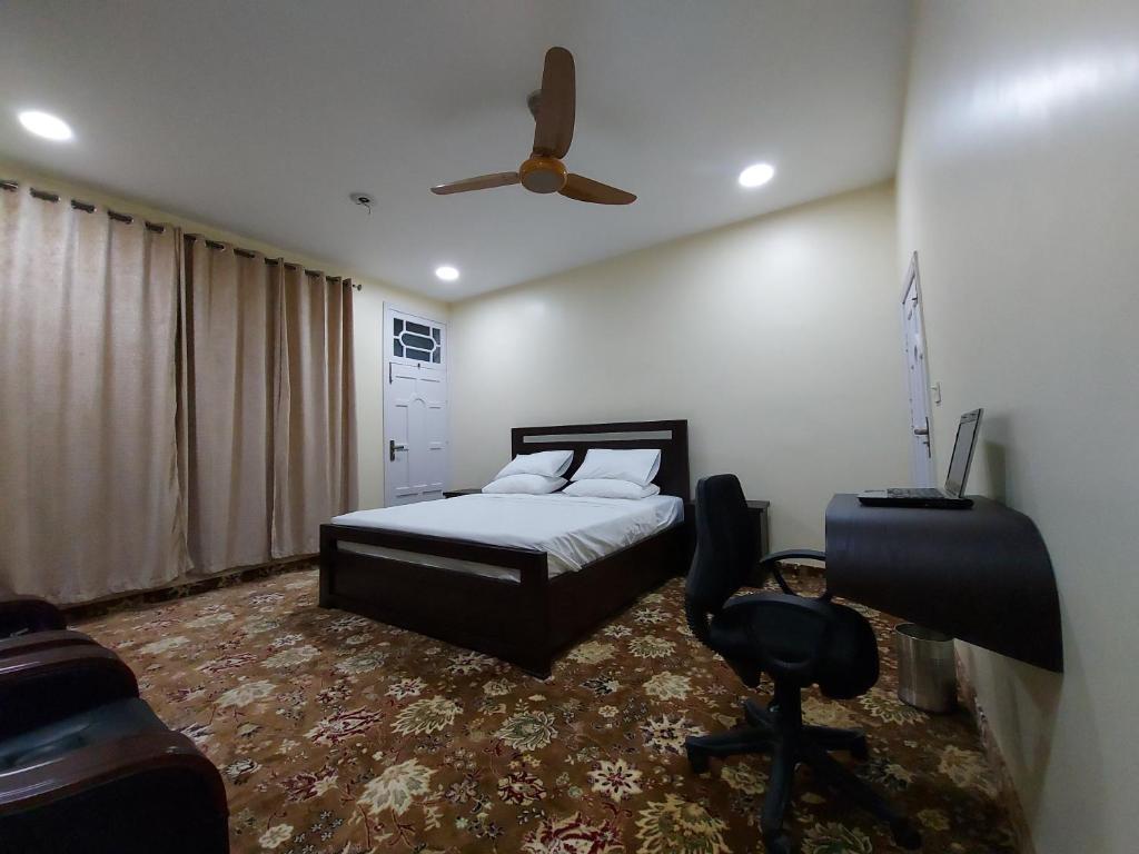 吉尔吉特Hotel Astro的一间卧室配有一张床和吊扇
