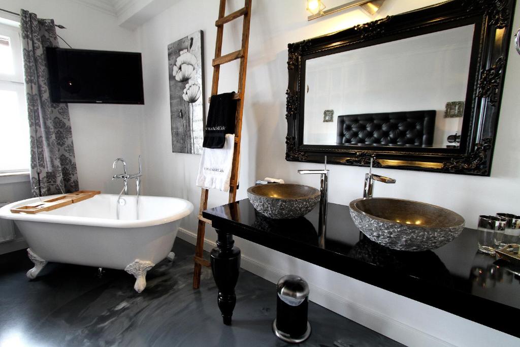 阿尔斯费尔德VILLA ADELEes BOUTIQUE HOTEL的浴室配有两个盥洗盆和浴缸。