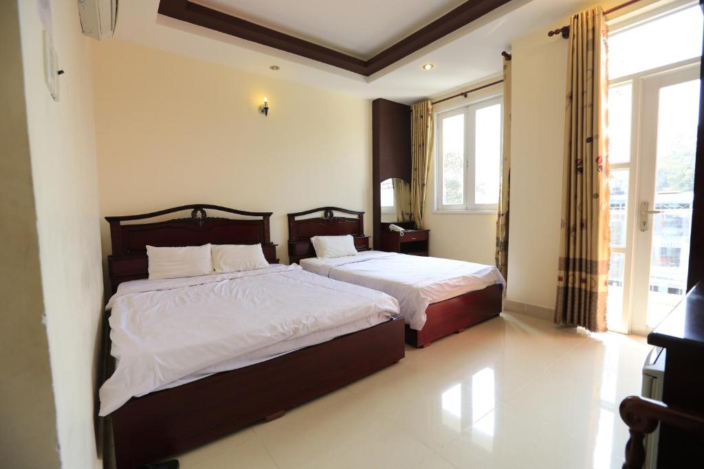 胡志明市The Art - Tuan Viet Hotel的一间卧室设有两张床和窗户。