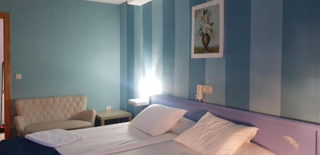 赫尔特HOTEL LOS ARENALES DE JERTE的卧室配有白色床和蓝色墙壁