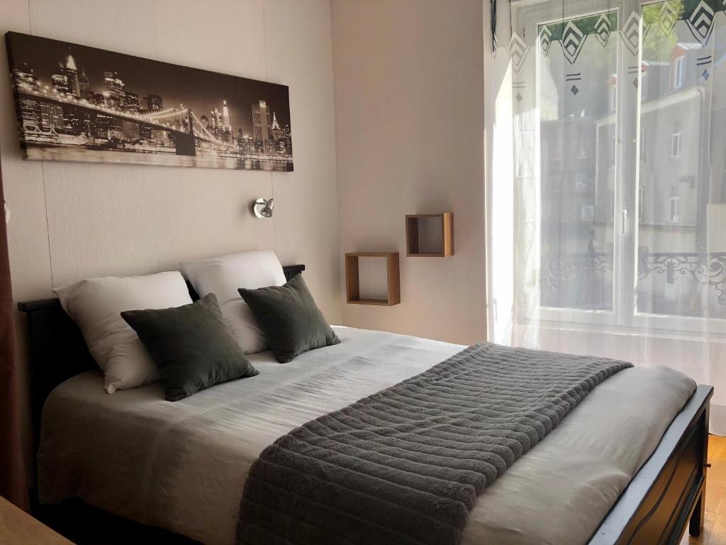 勒蒙多尔Residence Soleil des Thermes 2的一间卧室设有一张大床和大窗户