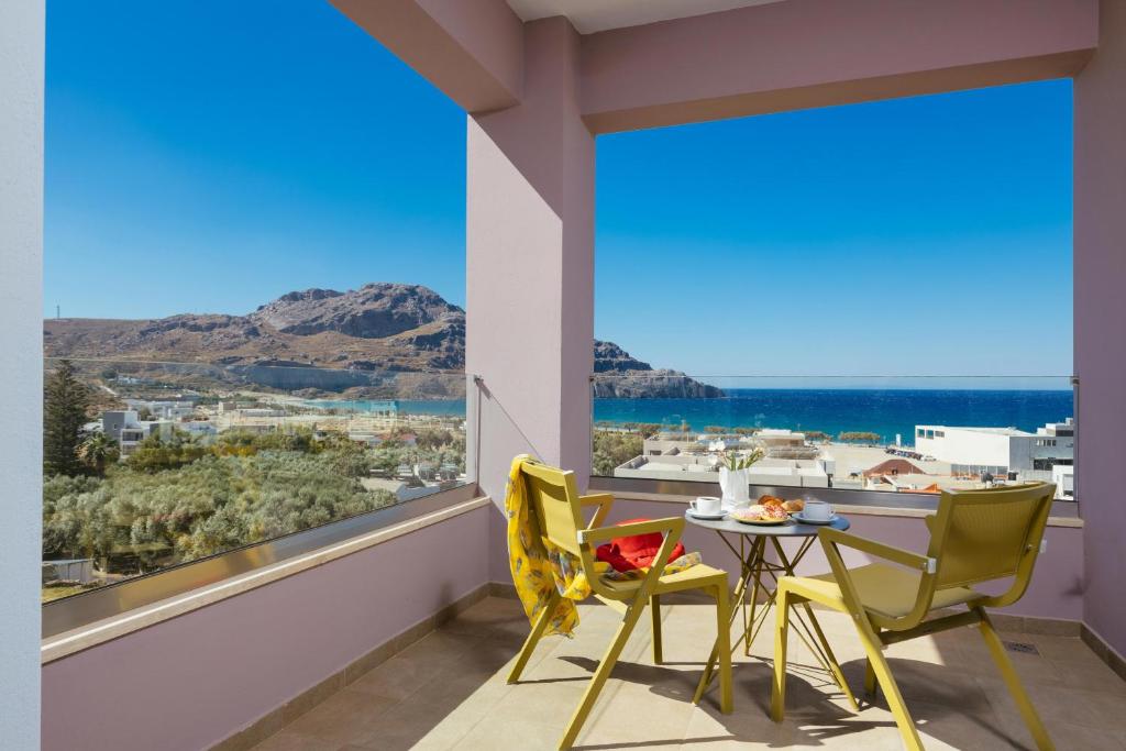 普拉基亚斯Sea View Luxury Apartments的阳台配有桌椅和大窗户。