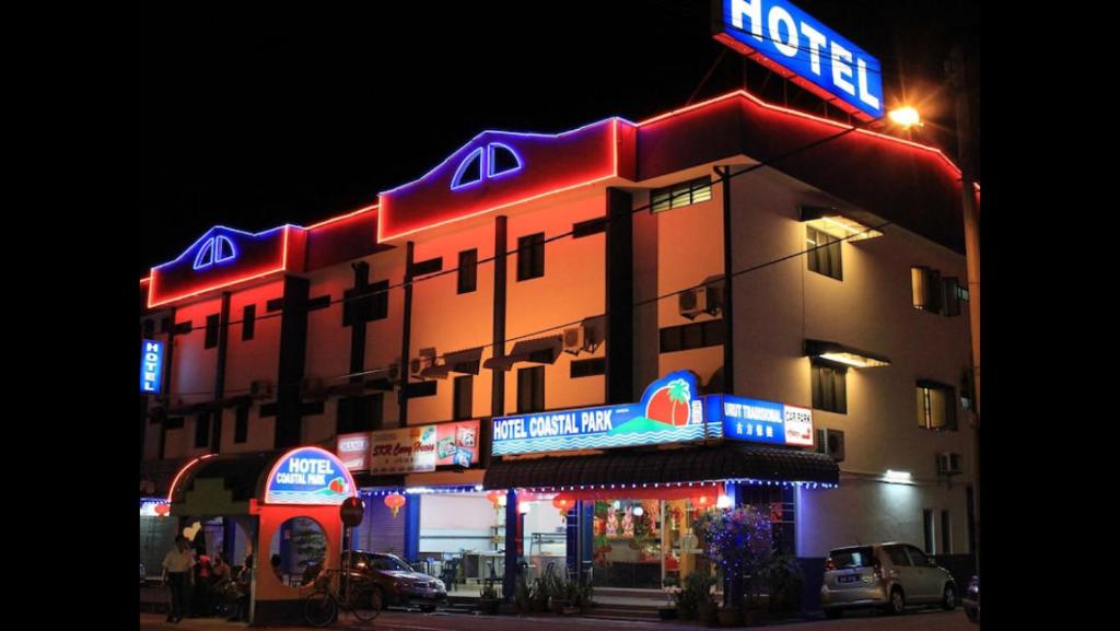 马六甲Coastal Park Hotel的建筑的侧面有 ⁇ 虹灯标志