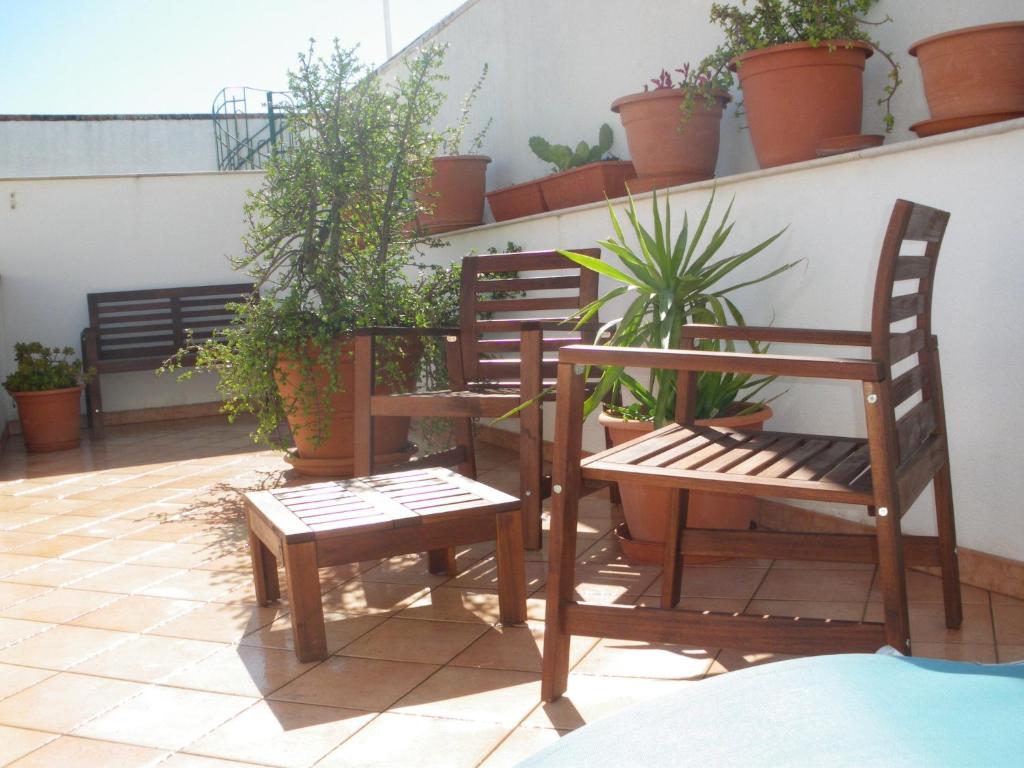 圣维托罗卡波CASE COLOMBO E MATTARELLA- Appartamenti centrali con wi-fi e parcheggio privato gratuito的植物阳台的两把椅子和一张桌子