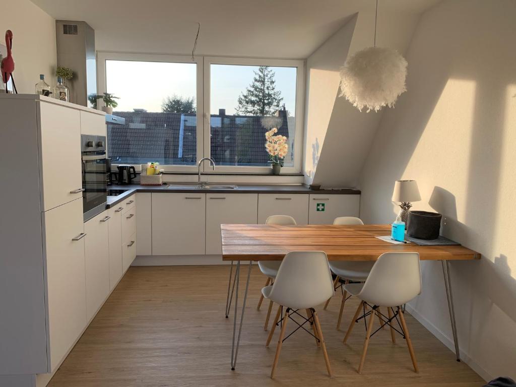 亚琛Apartment Brander Blick的厨房配有木桌和白色橱柜。