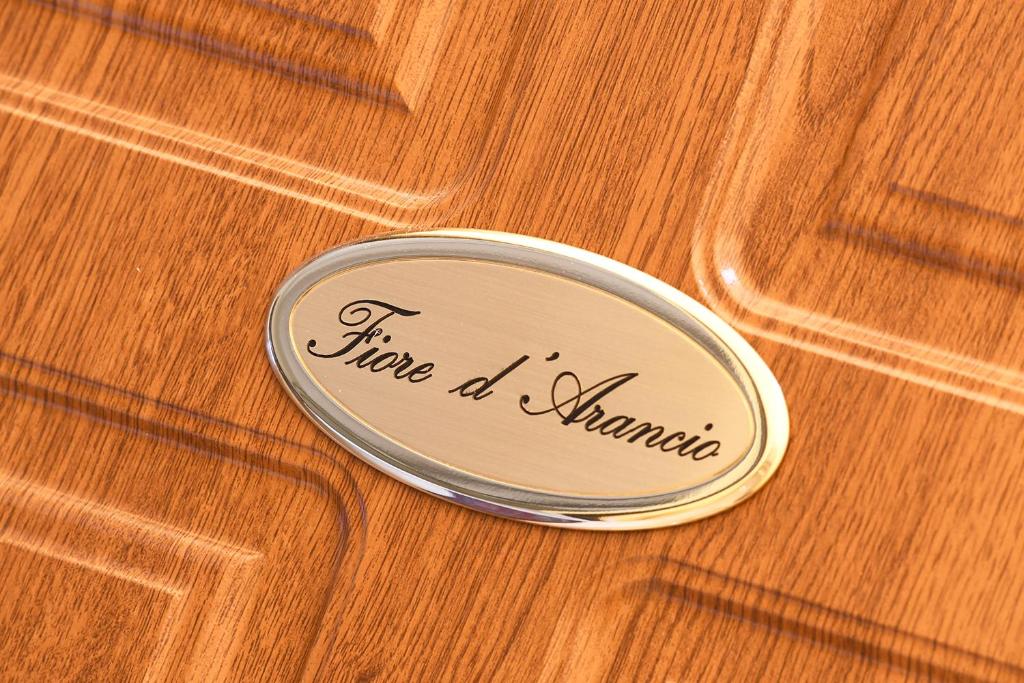 维罗纳Fiore d'arancio Luxury City Center Apartment的木桌上用词火烧焦的金属圆盘