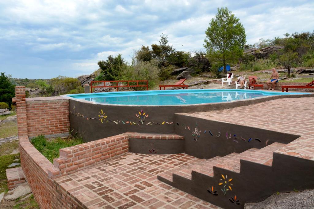 米娜克拉韦罗LA TOMA Complejo de Montaña - Cabañas y Habitaciones en Hosteria的四周环绕着砖墙的游泳池