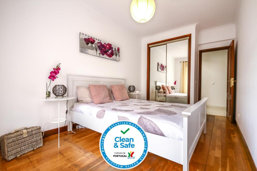 CacilhasApartamento Tejo的一间干净而安全的带一张床和镜子的卧室