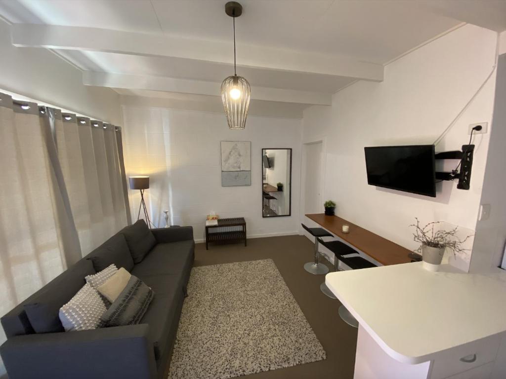 桑迪角Prom Coast Apartments的客厅配有沙发和桌子