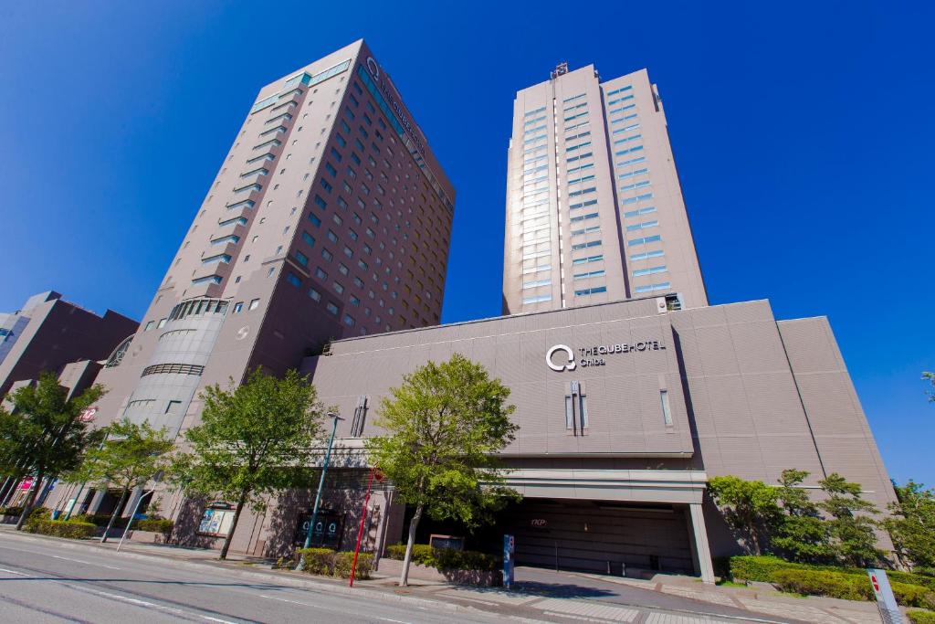 千叶The QUBE Hotel Chiba的两座树荫街道上的高楼