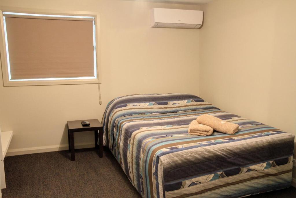 IvanhoeIvanhoe Hotel Motel的一间卧室配有一张床,上面有两条毛巾