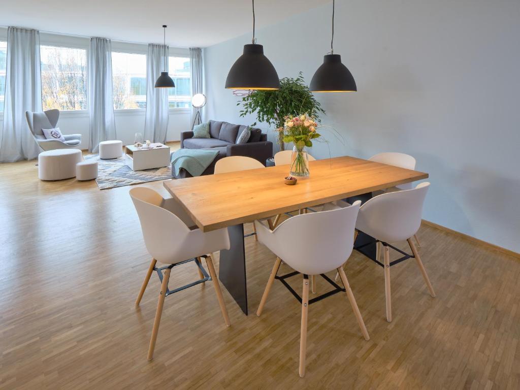 卢塞恩OfficeWerft Business-Apartments的用餐室以及带木桌和椅子的客厅。