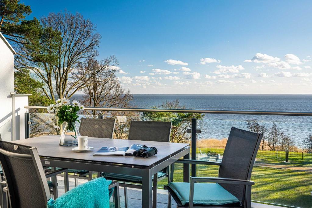 加兹尤瑟多姆Appartement "Kliffkante" mit Penthouseflair - Oase am Haff的海景阳台上的桌椅