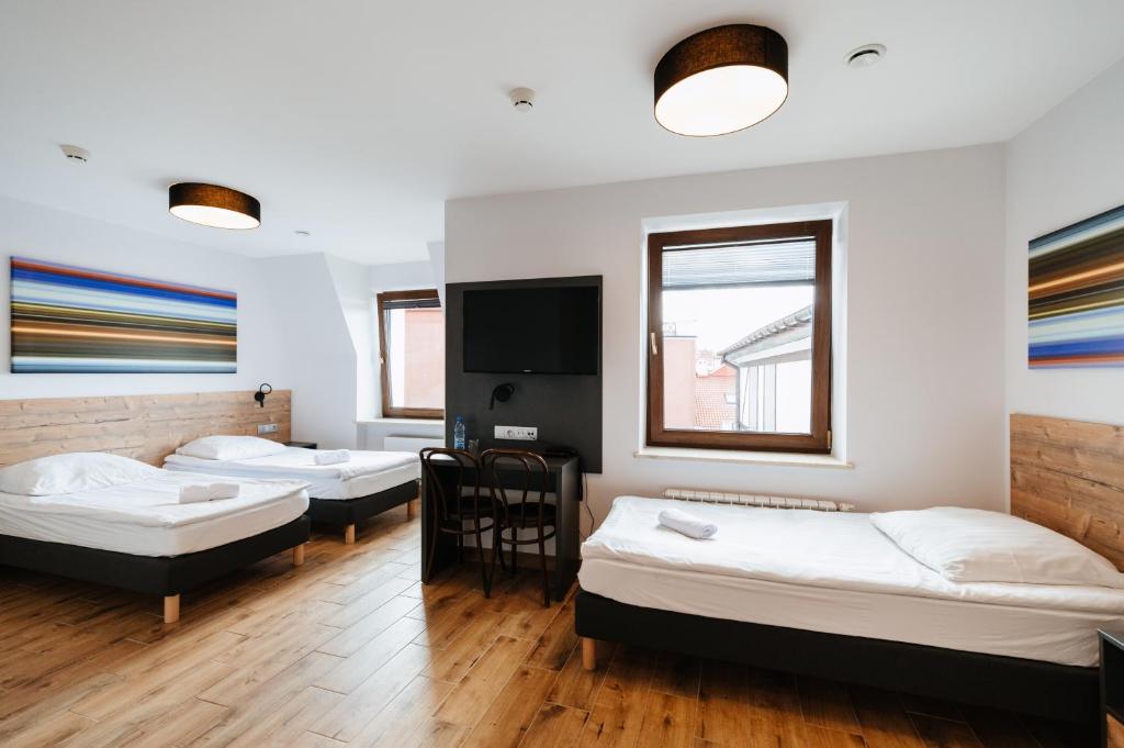 厄尔科Horeka Hotel & SPA的客房设有三张床和一台平面电视。