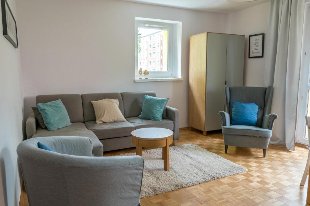 托伦Nest Comfort Toruń的客厅配有沙发和两把椅子