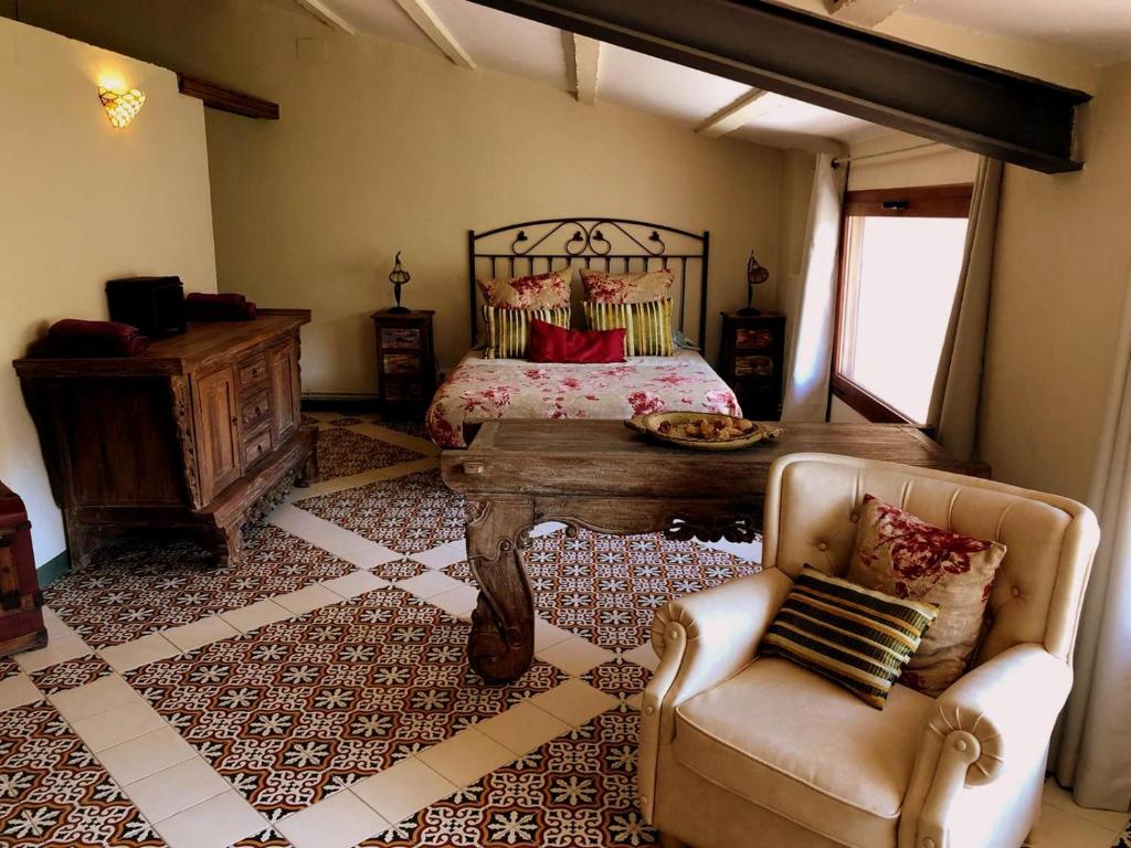 Os de BalaguerCal Tató的卧室配有1张床、1张桌子和1把椅子