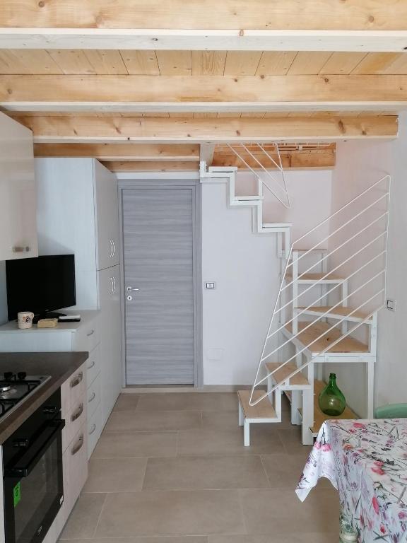 马蒂诺Kilò Corte Santa Lucia的一个小房子里的厨房,有螺旋楼梯