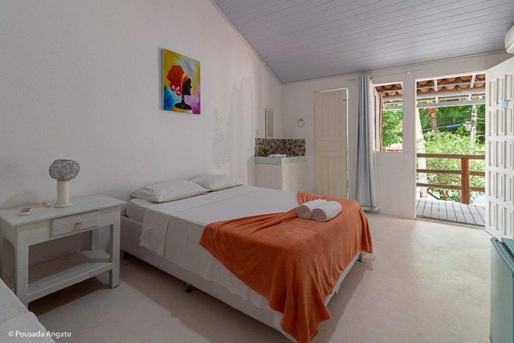 阿拉亚尔达茹达Pousada Angatu Arraial - Rua do mucugê的一间卧室配有一张带橙色毯子的床