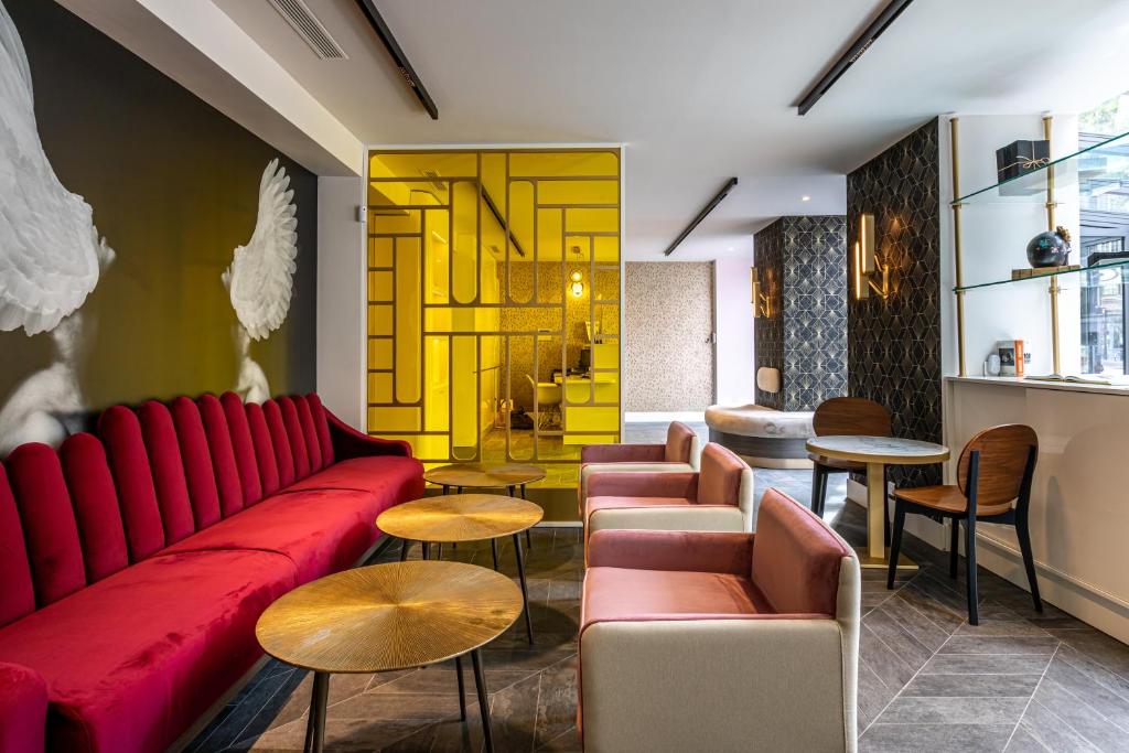 巴黎Hôtel Nude Paris - Color Vision的客厅配有红色的沙发和桌子