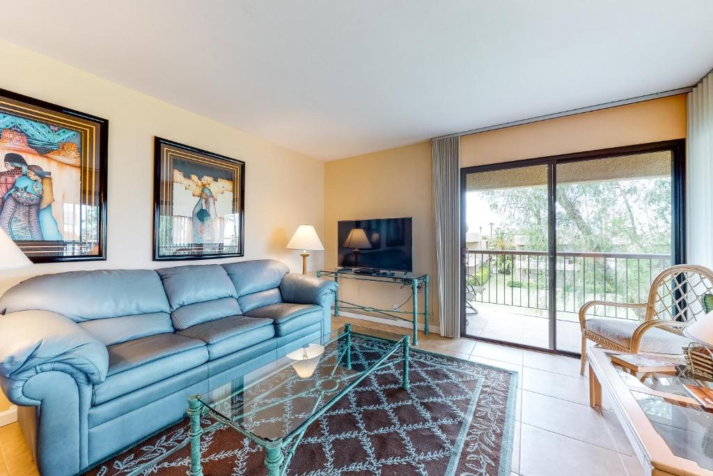 棕榈荒漠Palm Desert Paradise Permit# STR2020-0085的客厅配有蓝色的沙发和电视