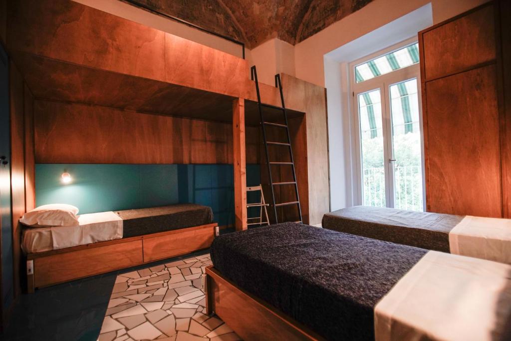 那不勒斯NAP Hostel Spaccanapoli的一间卧室设有两张双层床和一扇窗户。