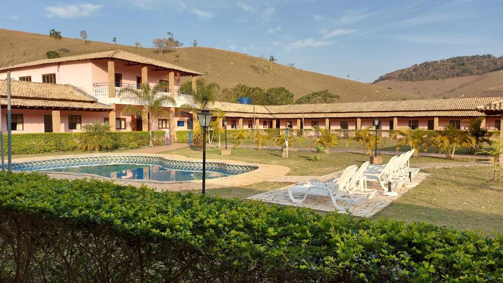 圣路易斯-杜帕赖廷加Pousada Recanto Nativa's的一个带游泳池和椅子的度假胜地和一座建筑